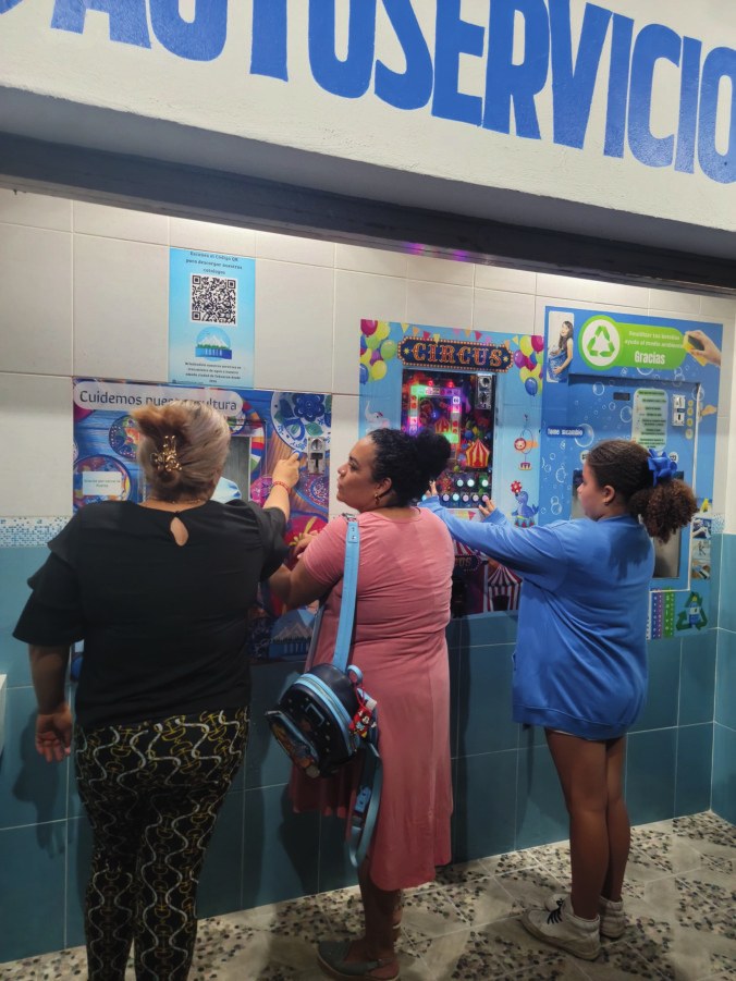 Clientas usando la estación de autoservicio Nuvem para surtir su garrafón
